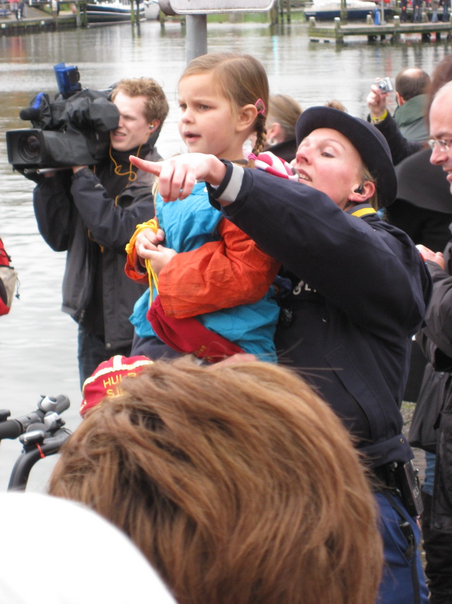 Een politieagente wijst Nienke waar de stoomboot aan komt varen